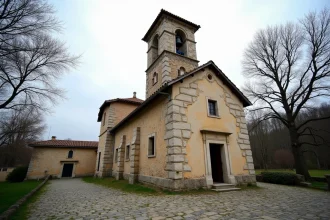Église historique en pierre de Sarralbe avec clocher roman et façade en calcaire, entourée d'arbres et de pavés anciens